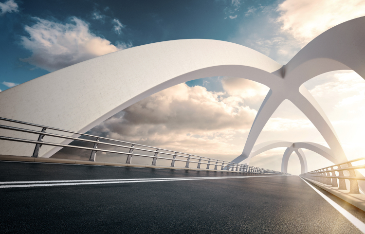 A empty road with a modern white bridge structure above